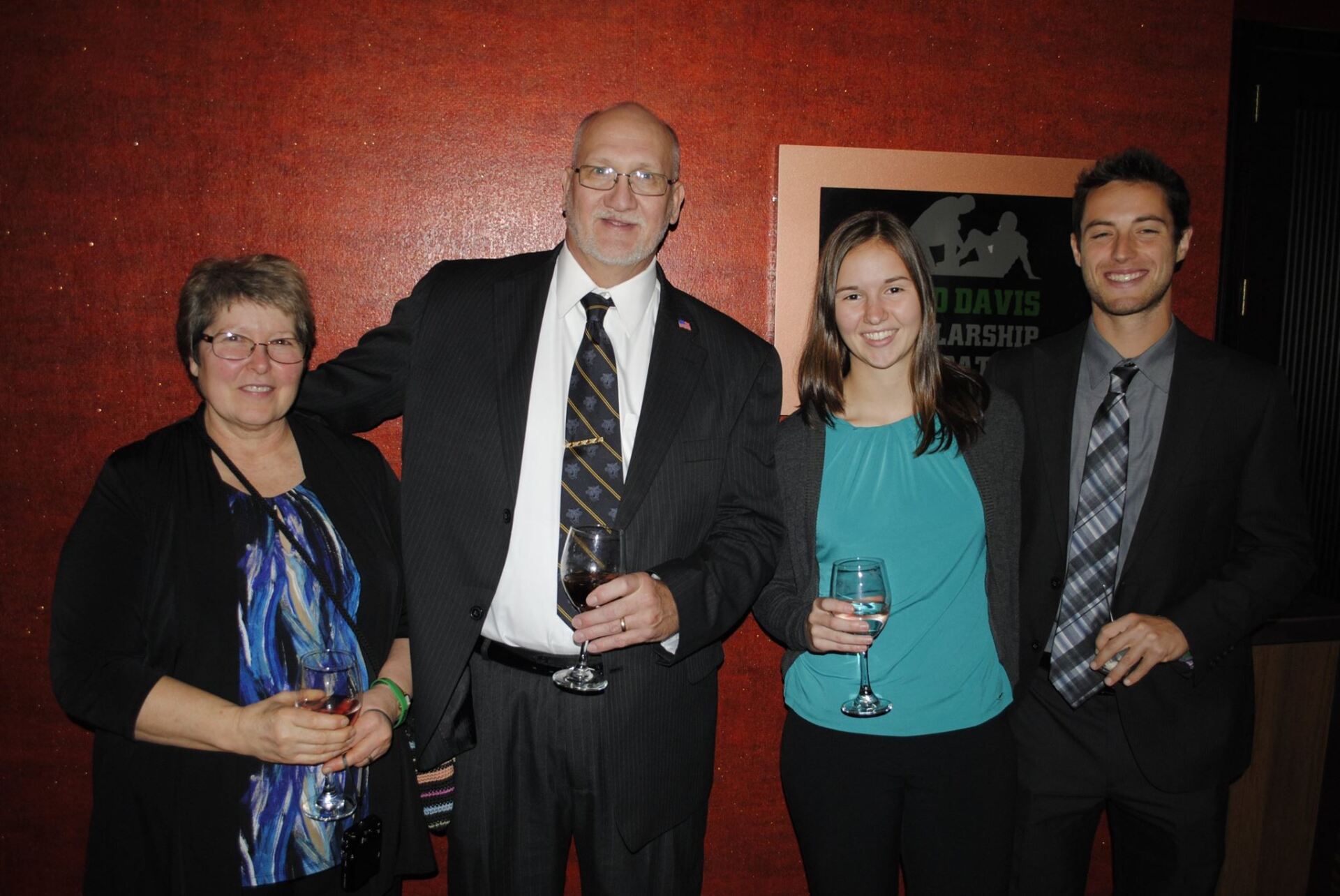 A group of people standing next to each other holding wine glasses