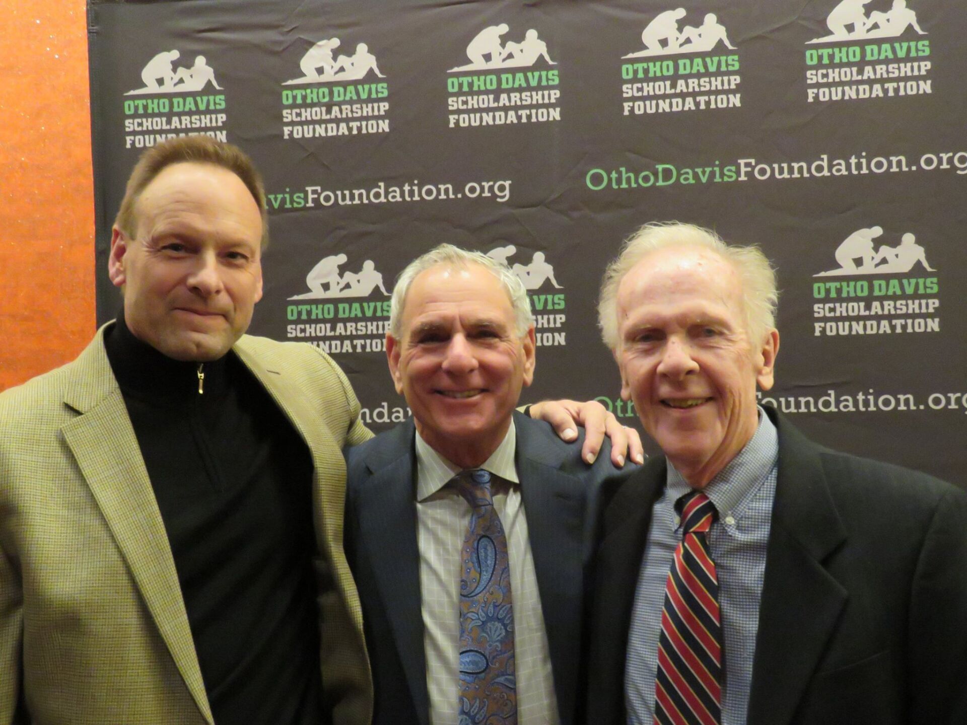 Three men are posing for a picture in front of a backdrop that says ohio davis scholarship foundation