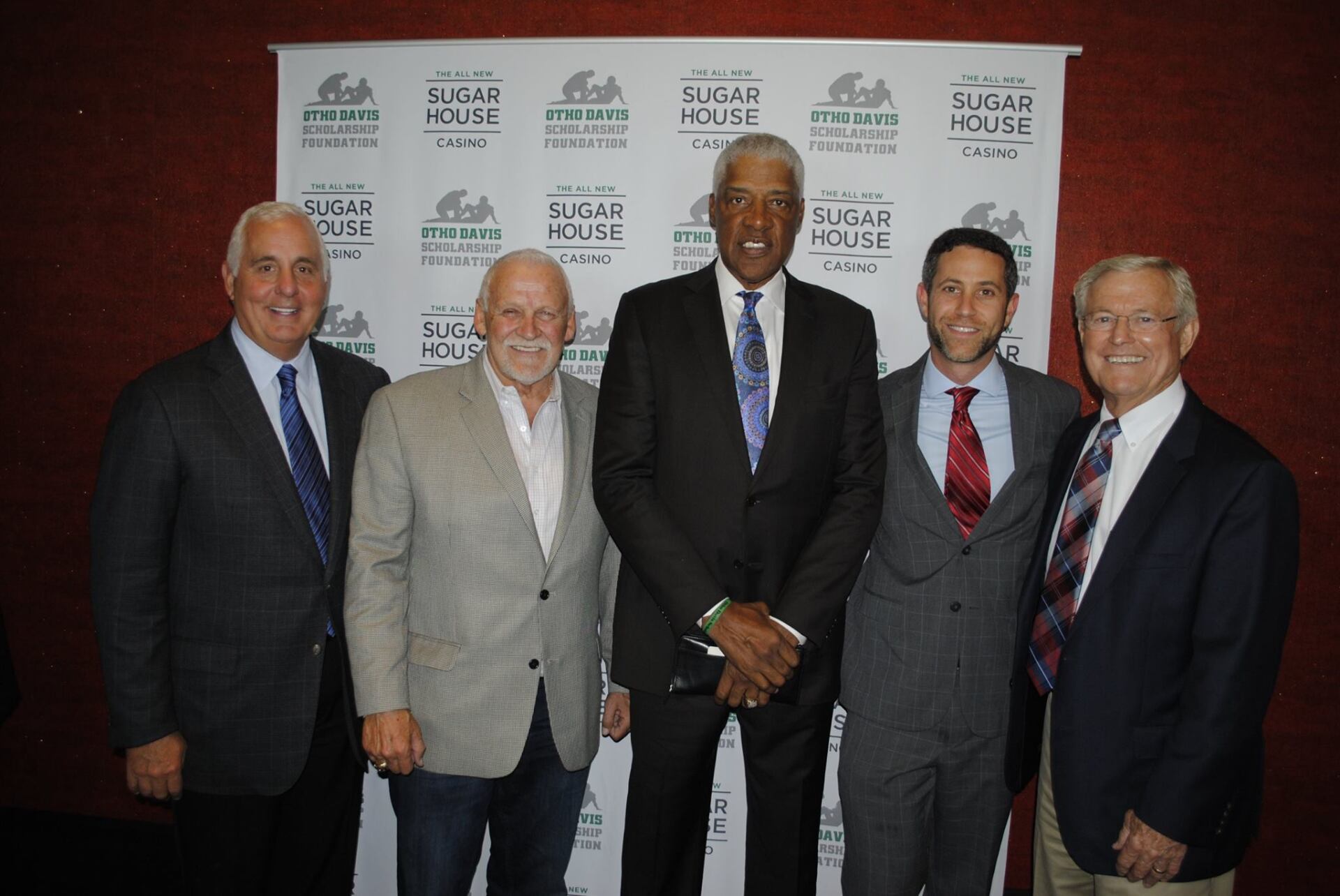 A group of men in suits and ties pose for a picture
