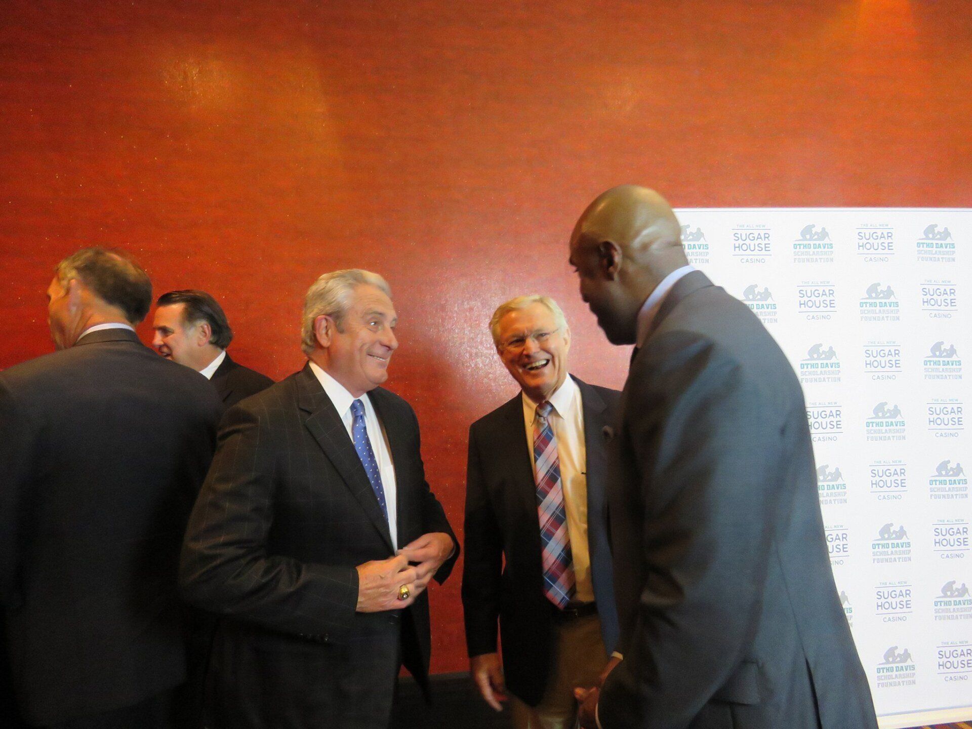 A group of men in suits and ties are shaking hands