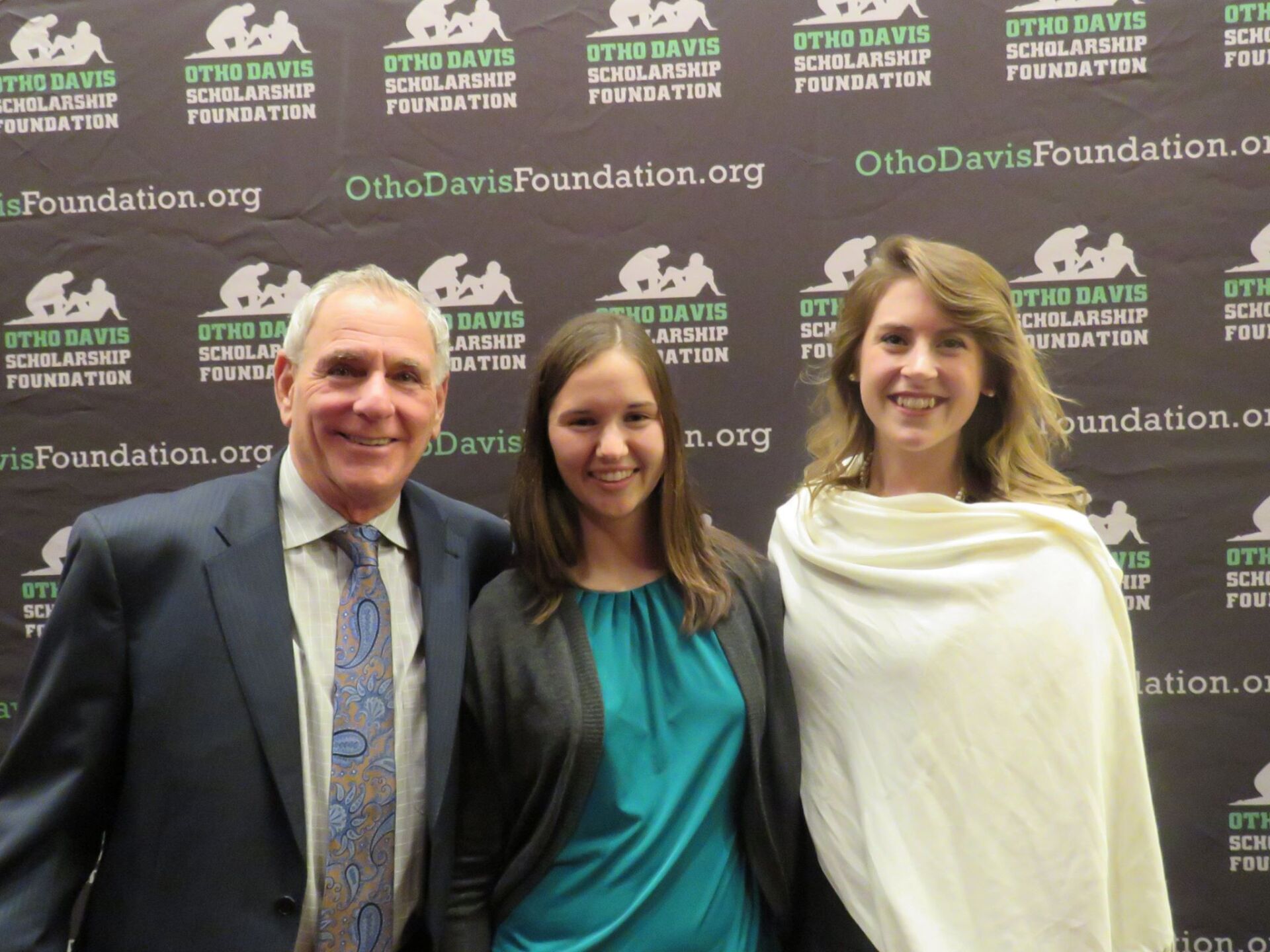 A man and two women pose in front of a ohio davis foundation banner