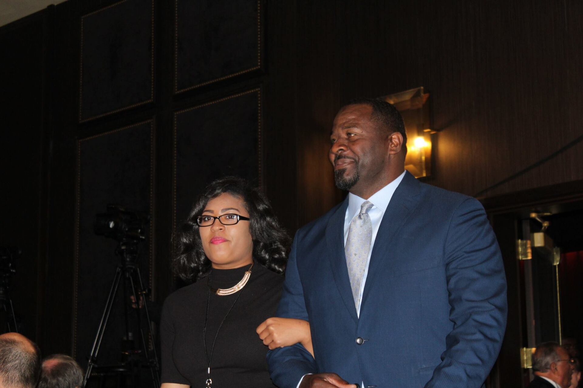 A man and a woman are standing next to each other in a dark room.