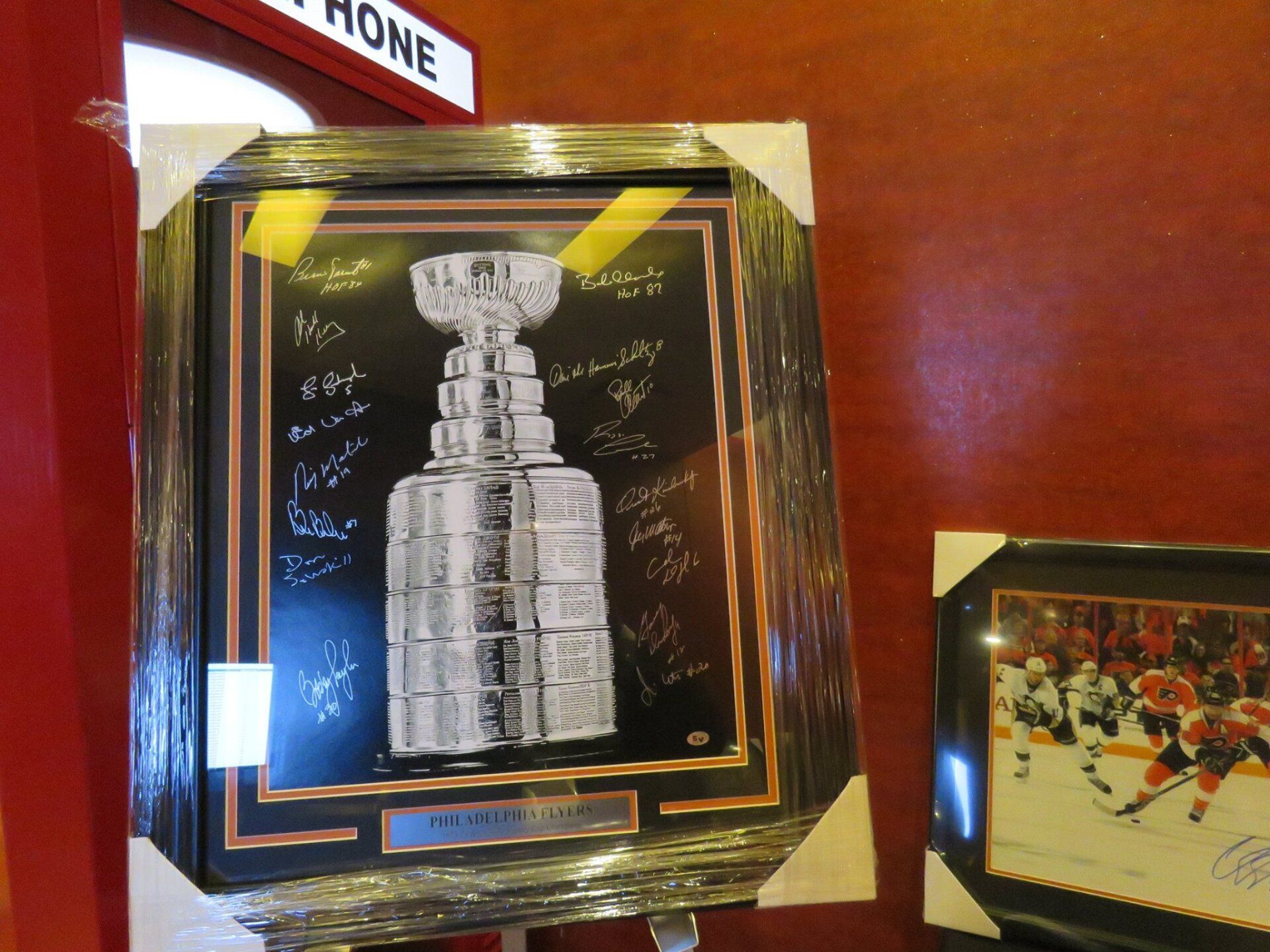 A framed picture of a hockey trophy with a sign above it that says phone