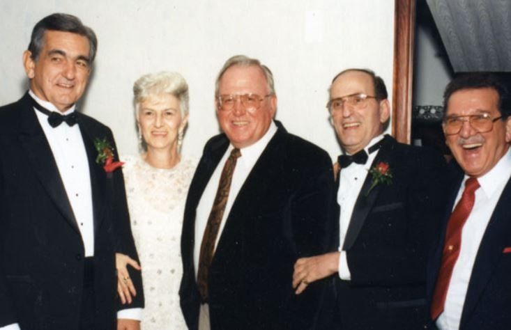 A group of men in tuxedos are posing for a picture