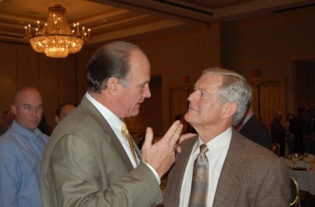 Two men in suits and ties are talking to each other