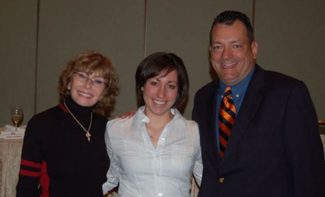 A man and two women are posing for a picture together