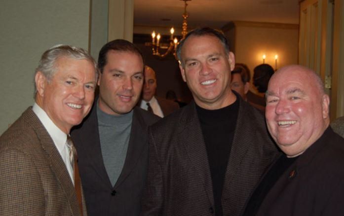 A group of men are posing for a picture and smiling