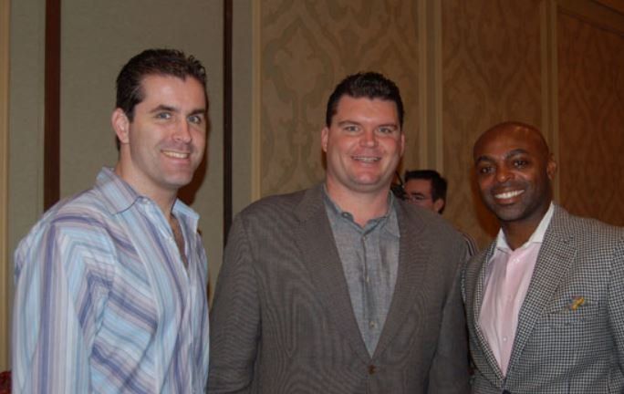 Three men are posing for a picture and smiling for the camera
