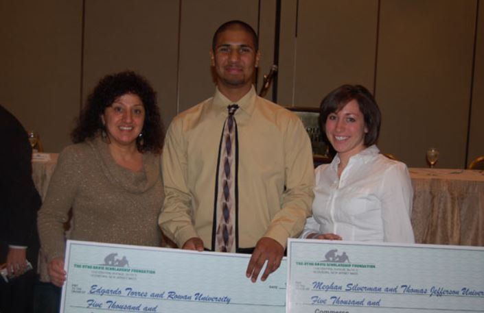 A man and two women are holding a check that says 