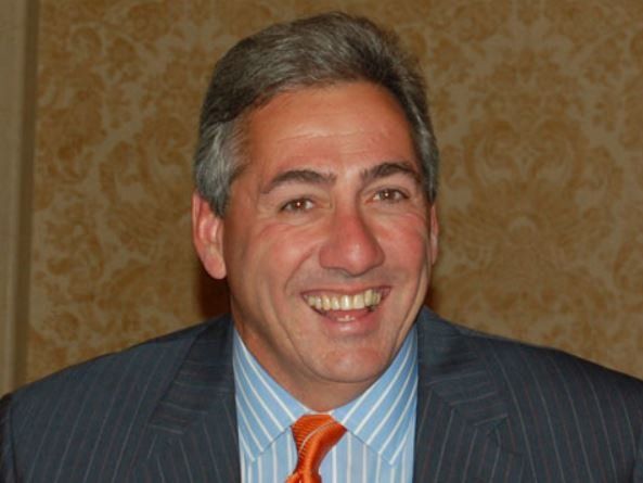 A man in a suit and tie smiles for the camera