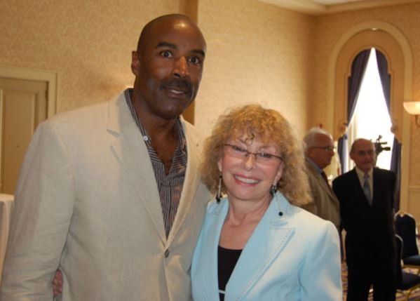 A man and a woman pose for a picture in a room