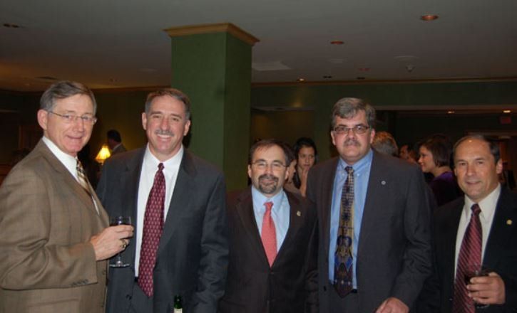A group of men in suits and ties are posing for a picture