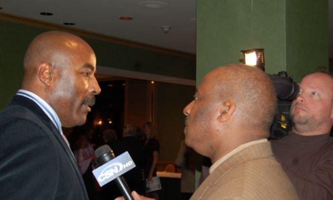 A man is talking into a microphone with cnn.com on it