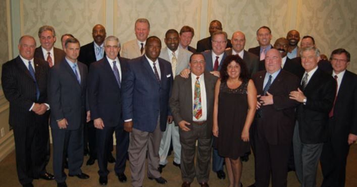 A group of men in suits and ties pose for a picture