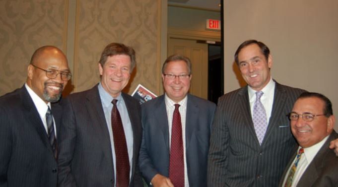 A group of men in suits and ties are posing for a picture