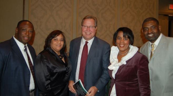 A group of people posing for a picture in front of an exit sign