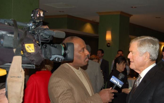 A man in a suit is being interviewed by a reporter with a microphone that says fox news