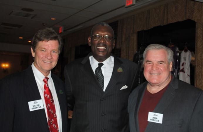 Three men in suits and ties are posing for a picture