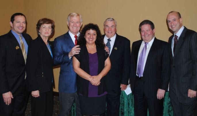 A group of men and women are posing for a picture