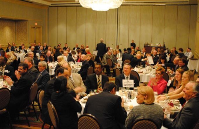 A large group of people are sitting at tables in a large room