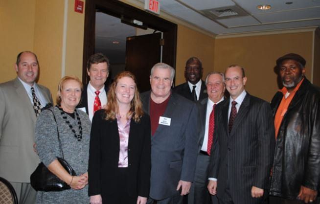 A group of people posing for a picture in front of an exit sign