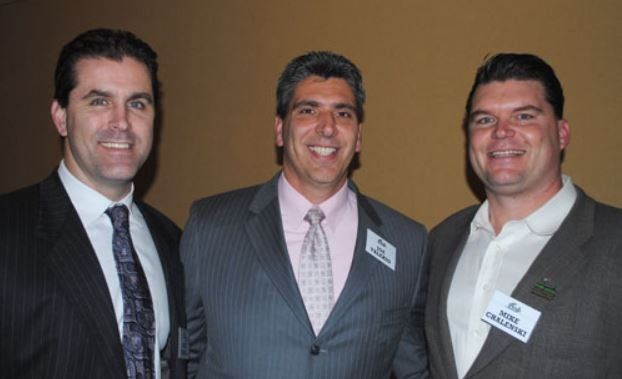 Three men in suits and ties are posing for a picture
