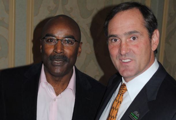 Two men in suits and ties are posing for a picture