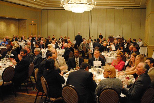 A large group of people are sitting at tables in a large room.