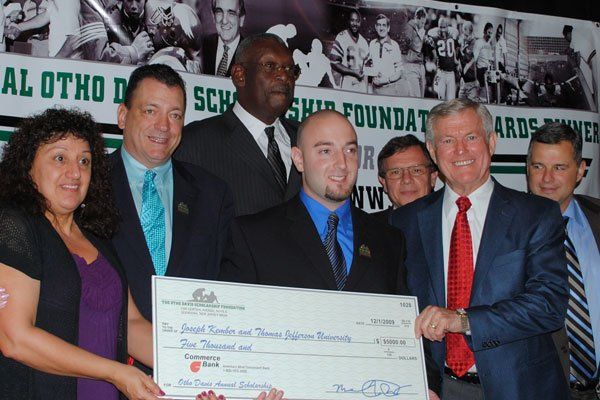 A group of men and women holding a large check