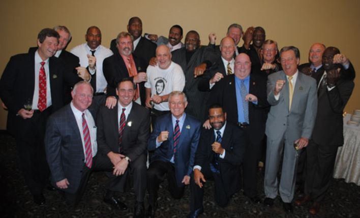 A group of men in suits and ties pose for a picture