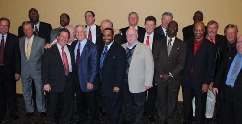 A group of men in suits and ties pose for a picture