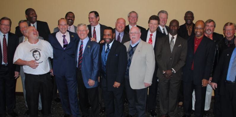 A group of men in suits and ties are posing for a picture