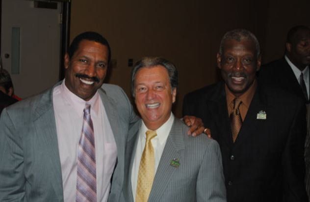 Three men in suits and ties pose for a picture