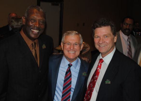 Three men in suits and ties pose for a picture