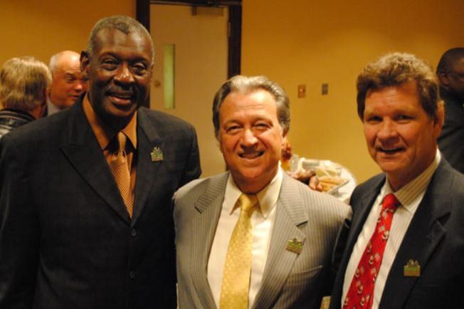 Three men in suits and ties pose for a picture