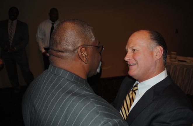 Two men in suits and ties are talking to each other