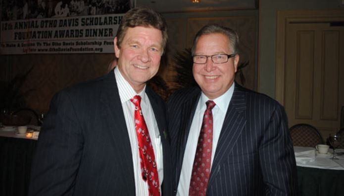 Two men in suits and ties are posing for a picture