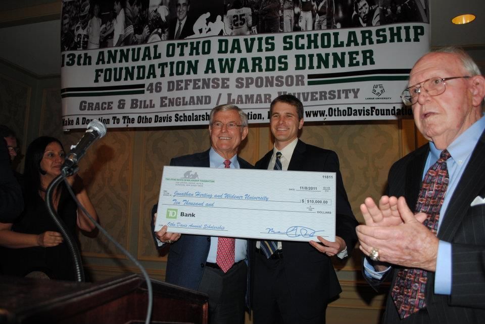 Three men holding a check in front of a sign that says 13th annual otho davis scholarship foundation awards dinner
