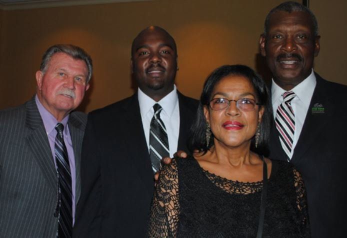 Three men and a woman pose for a picture together