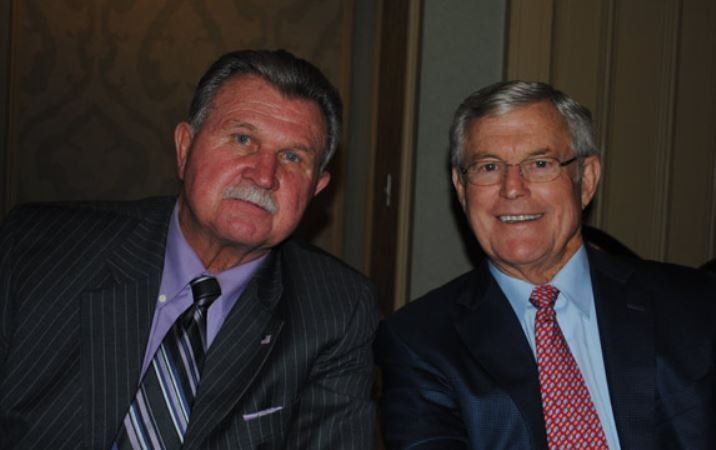 Two men in suits and ties are posing for a picture