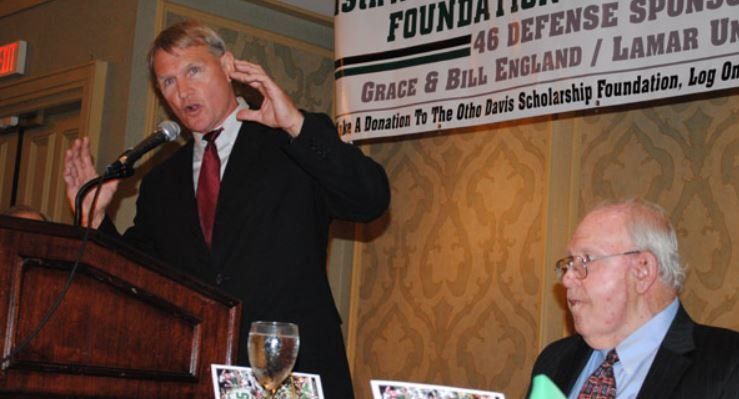 A man in a suit and tie is standing at a podium giving a speech