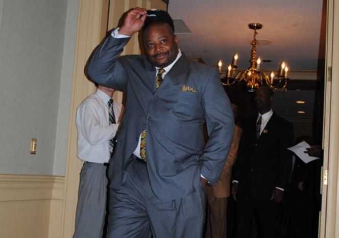 A man in a suit and tie is walking through a doorway