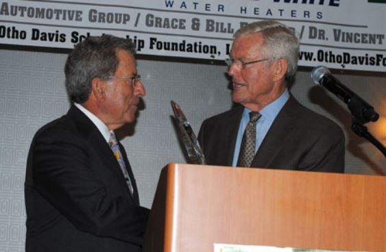 Two men shaking hands in front of a sign that says automotive group