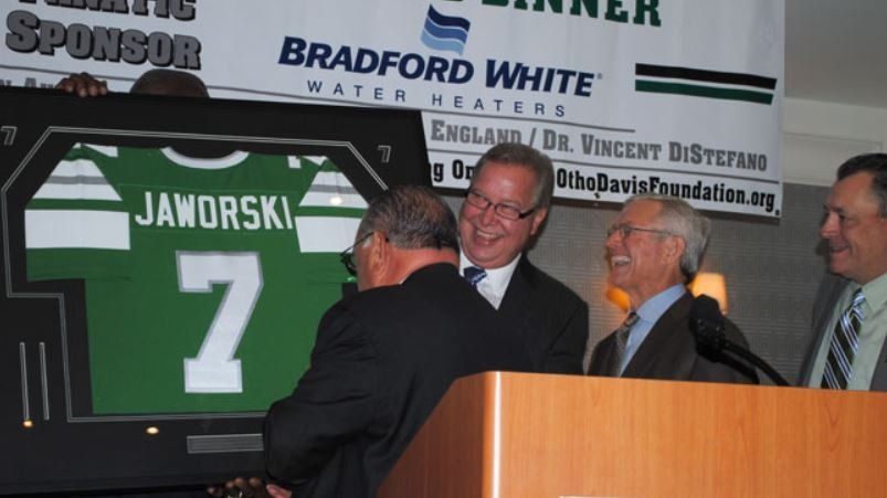 A man holding a jersey with the number 7 on it