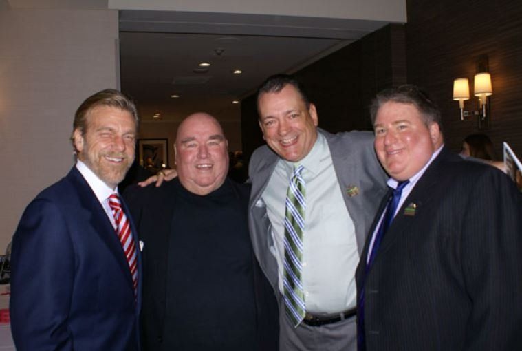 A group of men in suits and ties are posing for a picture.