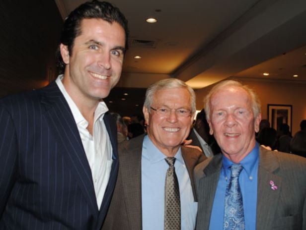 Three men in suits and ties pose for a picture