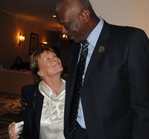 A man in a suit and tie is standing next to a woman