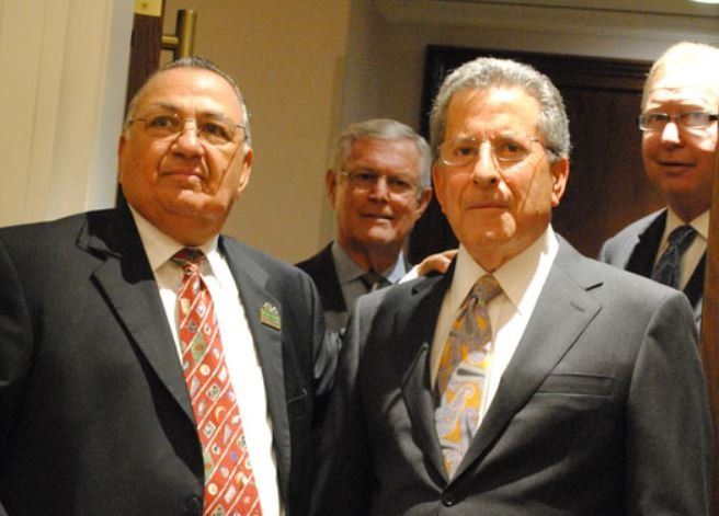 A group of men in suits and ties pose for a picture
