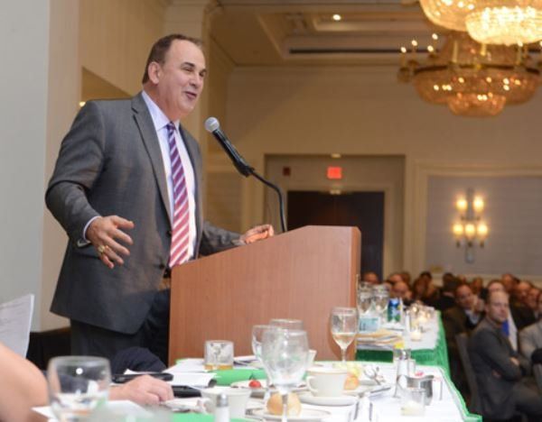 A man in a suit and tie is giving a speech at a podium