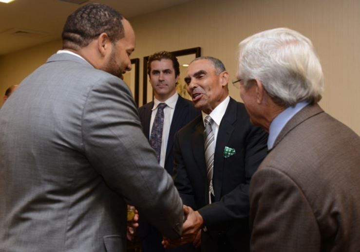 A group of men in suits and ties are shaking hands